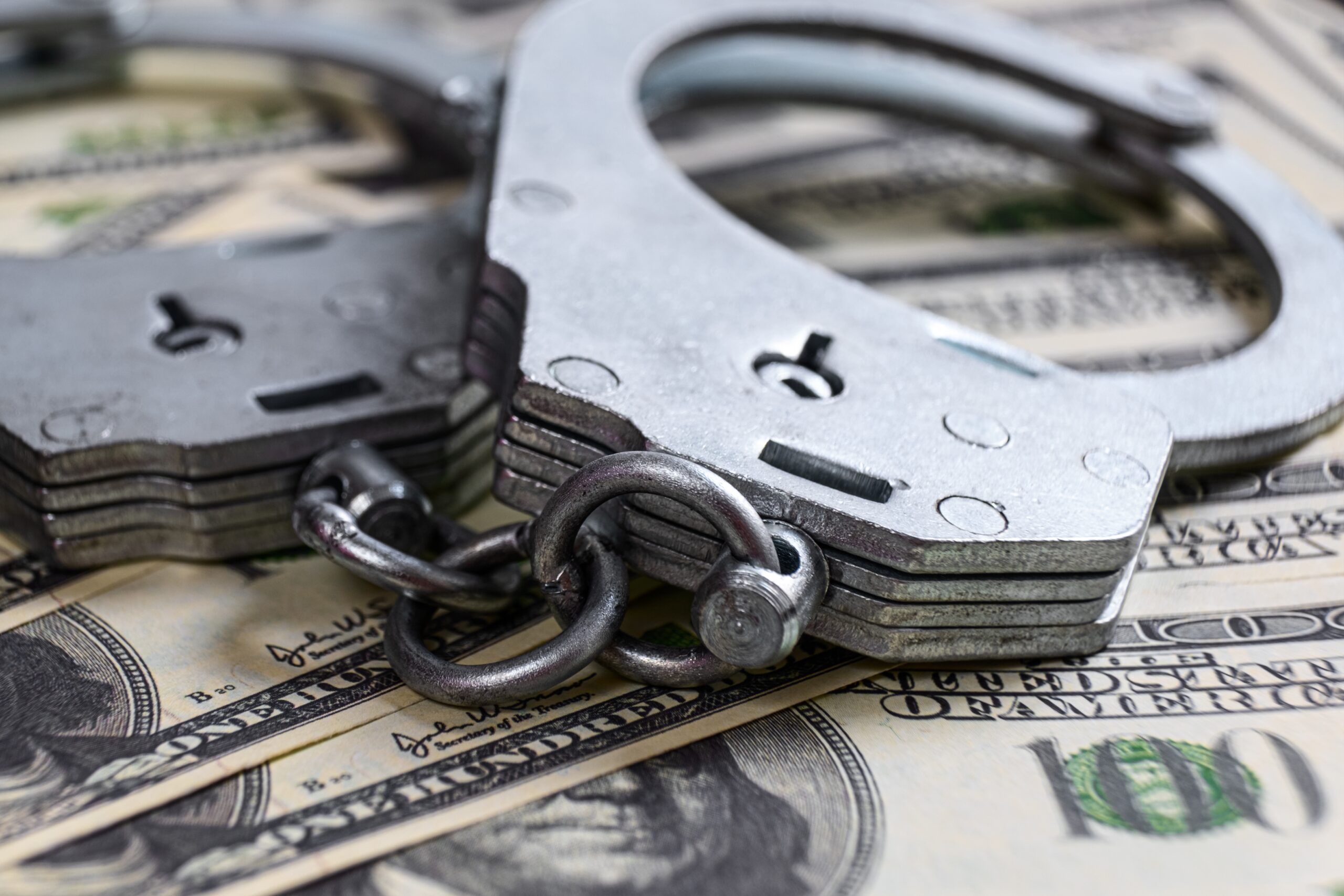Bail Bonds Bail Bonds: Handcuffs sitting on hundred dollar bills